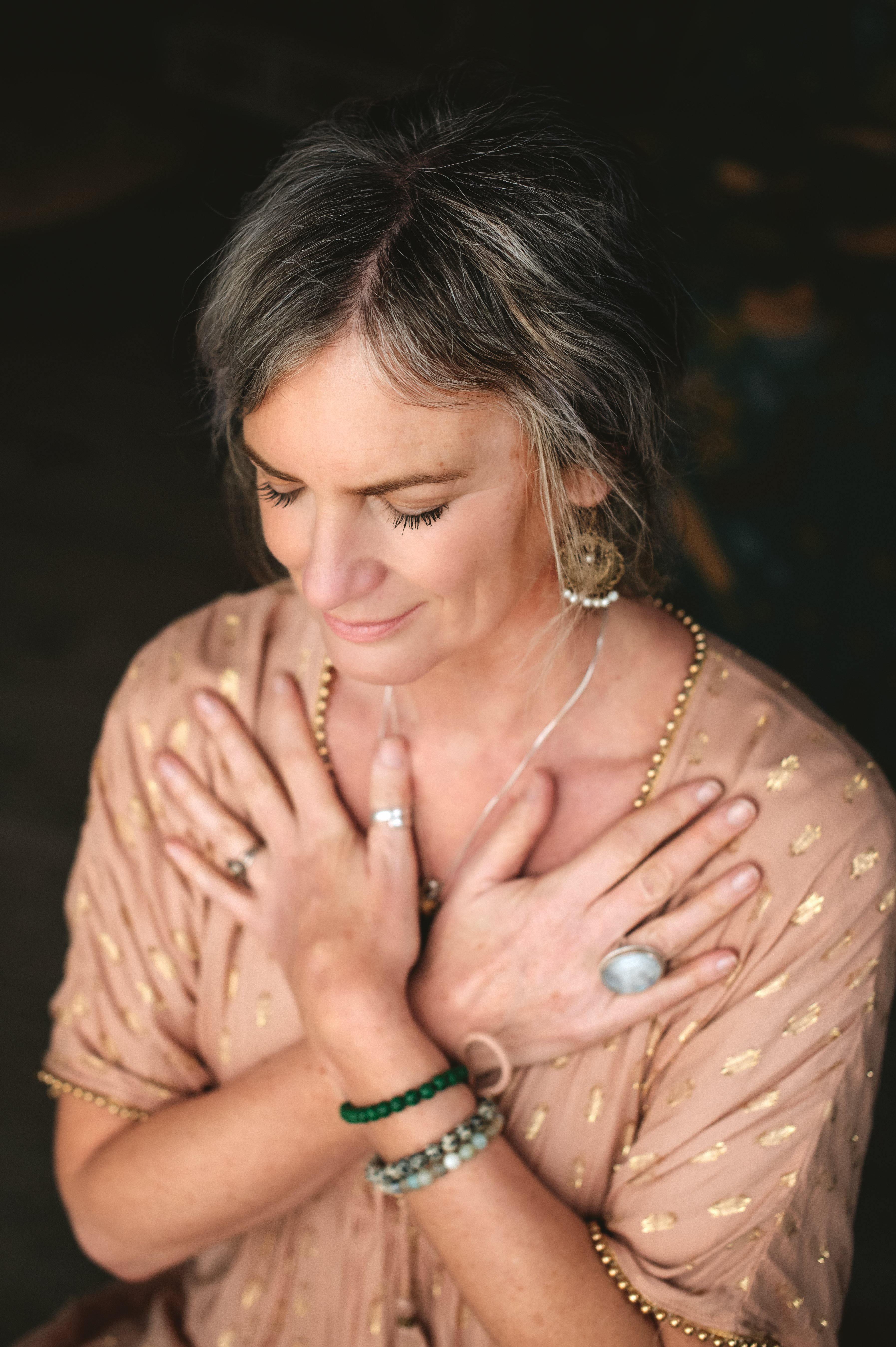Suzannah in pink, with her eyes closed and hands resting across her chest